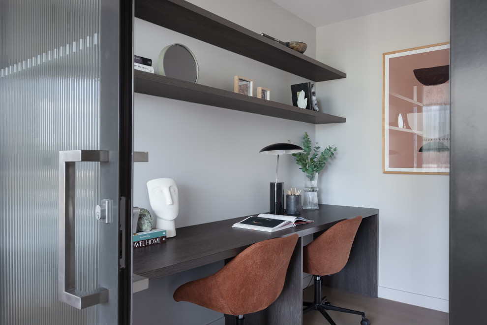 Inspiration pour un bureau design avec un mur blanc, parquet clair, un bureau intégré et un sol beige.