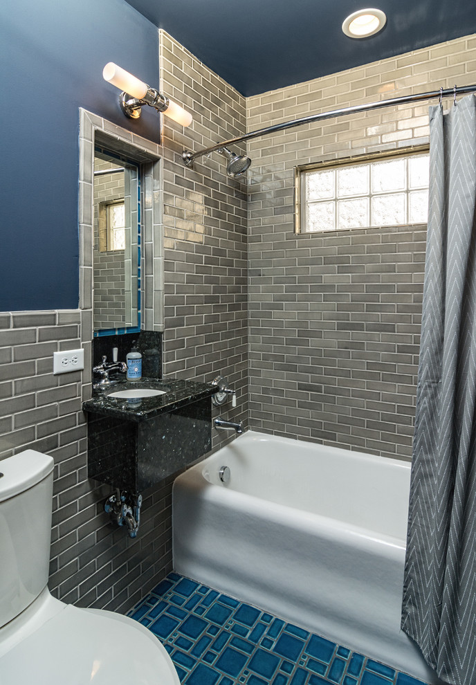 Small arts and crafts 3/4 bathroom in Minneapolis with an alcove tub, a shower/bathtub combo, a one-piece toilet, gray tile, subway tile, blue walls, ceramic floors, a pedestal sink, granite benchtops, blue floor, a shower curtain and black benchtops.
