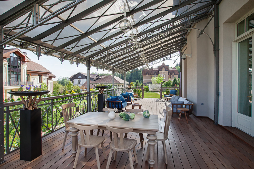 Photo of a large contemporary side yard verandah in Moscow with a roof extension and decking.