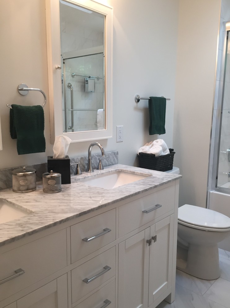 Inspiration for a mid-sized transitional gray tile and porcelain tile porcelain tile home design remodel in Indianapolis with flat-panel cabinets, white cabinets, a one-piece toilet, white walls, an undermount sink and marble countertops