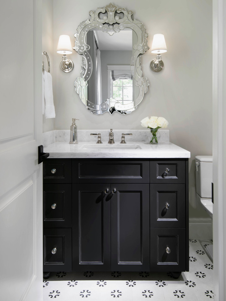 Mid-sized mediterranean powder room in Phoenix with black cabinets, marble benchtops, a built-in vanity and recessed-panel cabinets.