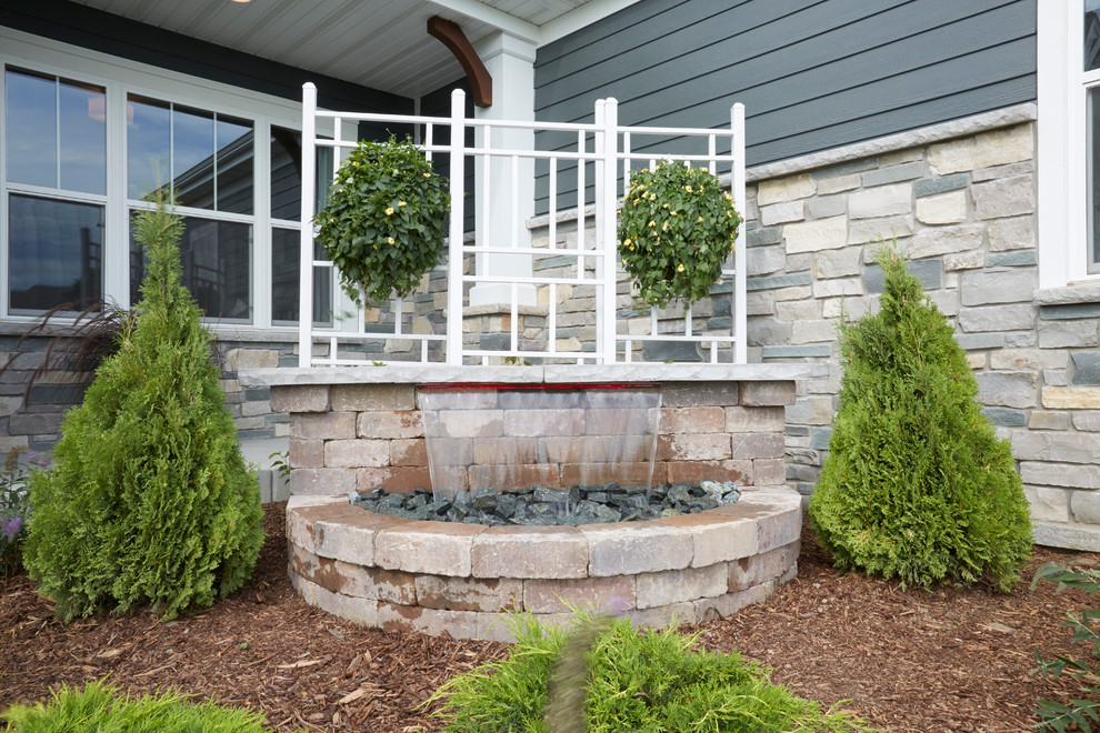 This is an example of an arts and crafts front yard verandah in Milwaukee with a water feature.