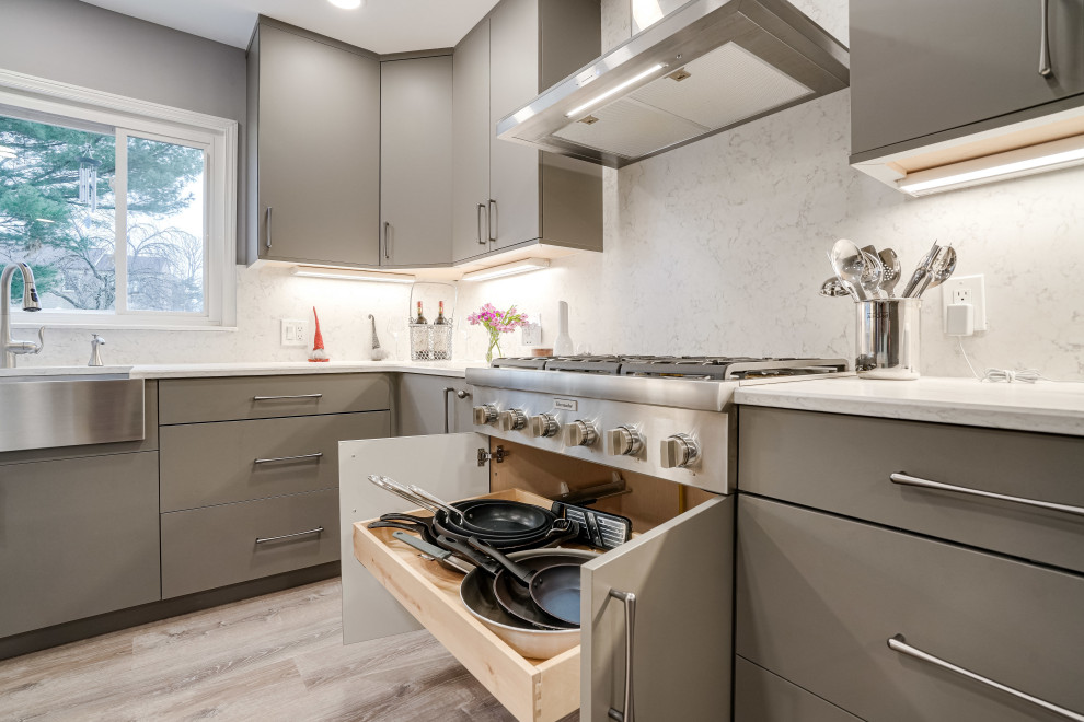 This is an example of an expansive contemporary u-shaped eat-in kitchen in DC Metro with a farmhouse sink, flat-panel cabinets, brown cabinets, quartz benchtops, engineered quartz splashback, stainless steel appliances and with island.