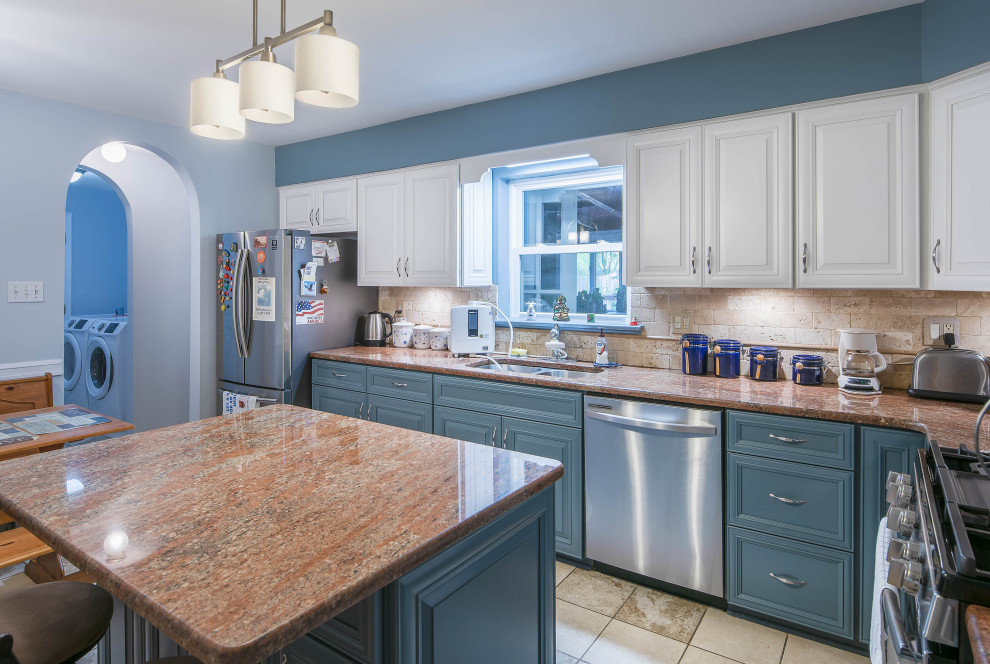This is an example of a mid-sized transitional l-shaped separate kitchen in Baltimore with an undermount sink, recessed-panel cabinets, blue cabinets, granite benchtops, beige splashback, stone tile splashback, stainless steel appliances, ceramic floors, with island, beige floor and orange benchtop.