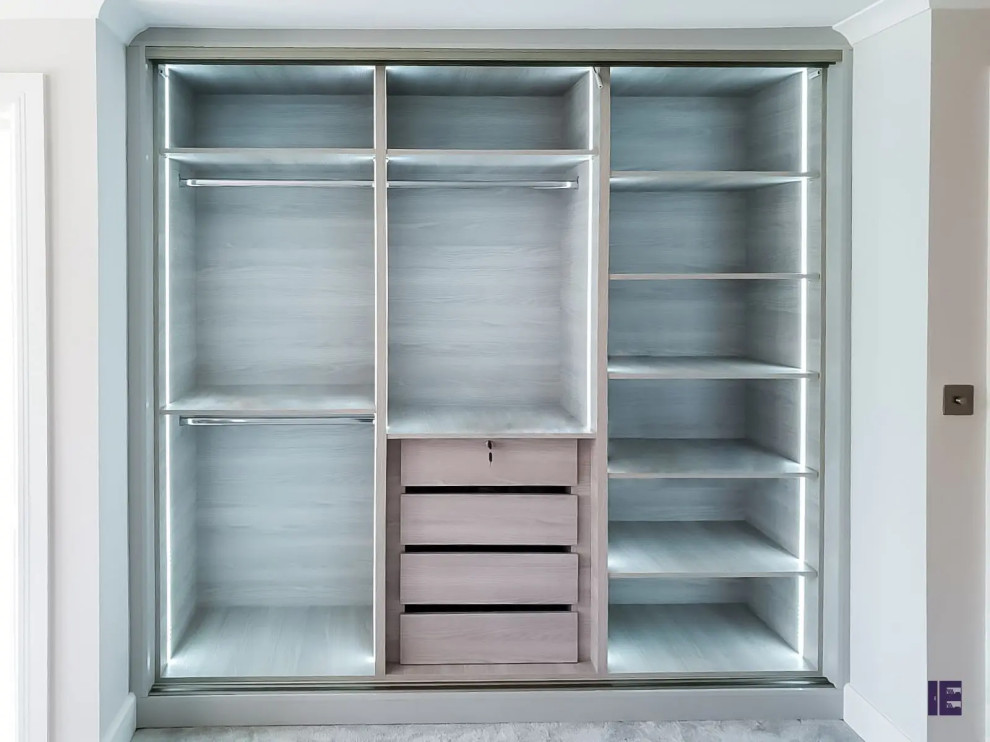 Photo of a contemporary storage and wardrobe in London with flat-panel cabinets.
