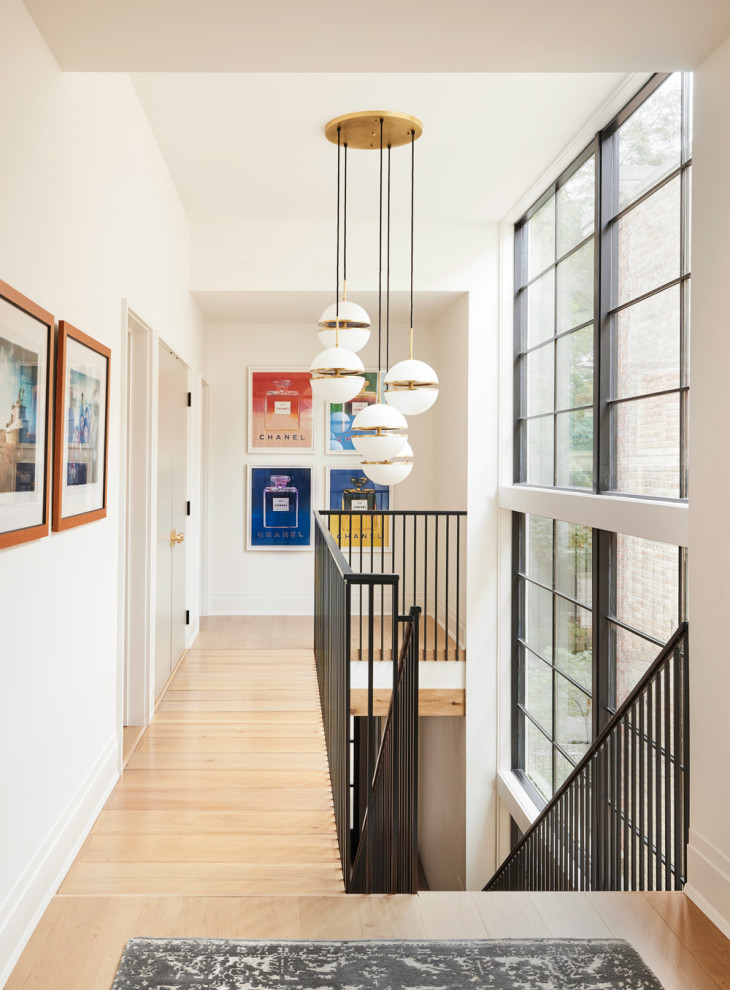 Contemporary hallway in Chicago with white walls and light hardwood floors.