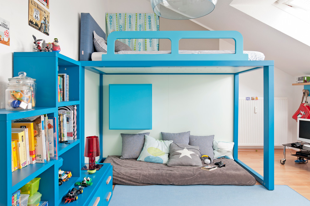 This is an example of a mid-sized contemporary kids' room for boys in Dusseldorf with white walls, medium hardwood floors and brown floor.