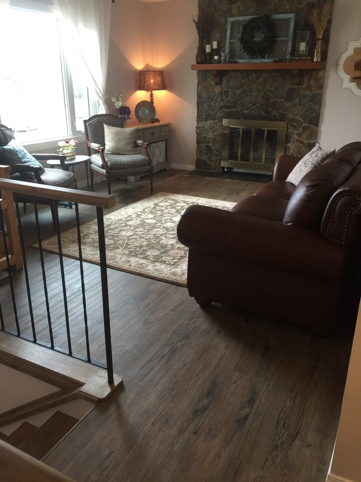 Photo of a small country enclosed living room in Calgary with grey walls, vinyl floors, a standard fireplace, a stone fireplace surround and no tv.