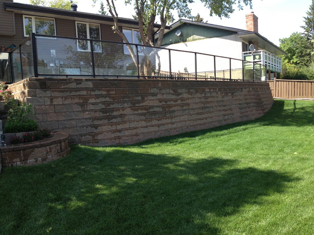 Completed engineered retaining wall with glass railing