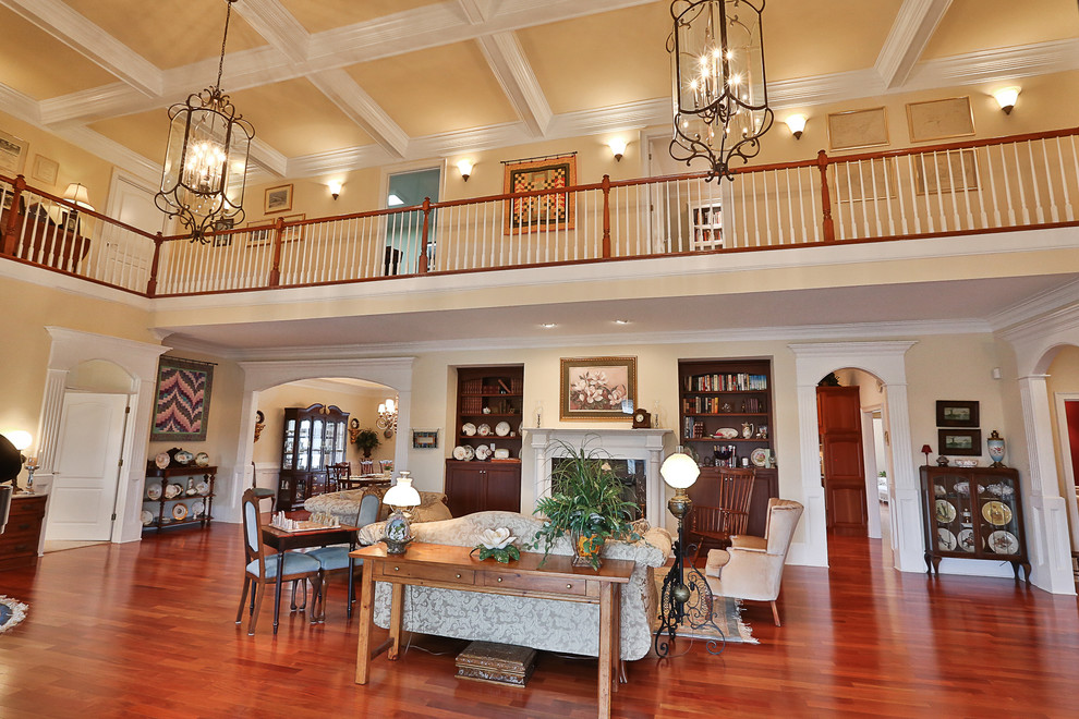 Photo of a large traditional formal open concept living room in Atlanta with yellow walls, medium hardwood floors, a standard fireplace, a stone fireplace surround and no tv.