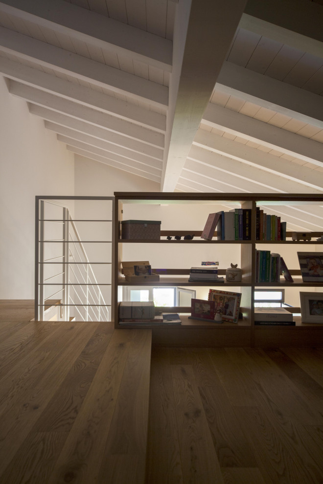 Inspiration pour un petit bureau nordique avec une bibliothèque ou un coin lecture, un mur bleu, un sol en bois brun et poutres apparentes.
