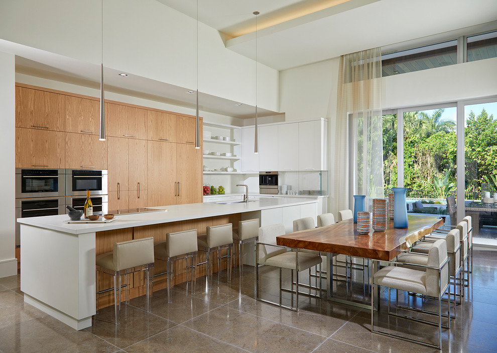 Photo of a large modern u-shaped eat-in kitchen in Miami with an undermount sink, flat-panel cabinets, light wood cabinets, quartz benchtops, white splashback, stone slab splashback, stainless steel appliances, porcelain floors, with island, multi-coloured floor and white benchtop.