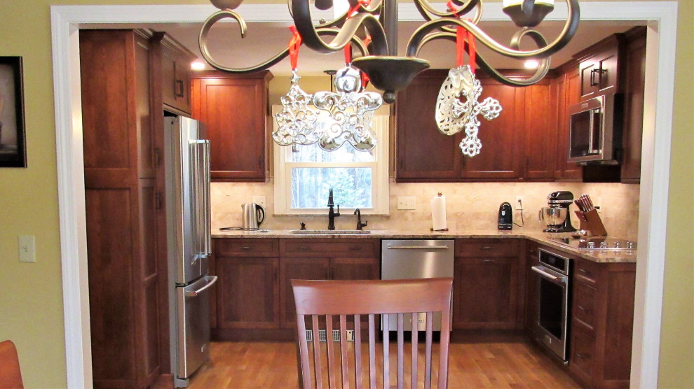 Enclosed kitchen - mid-sized transitional u-shaped light wood floor and brown floor enclosed kitchen idea in Boston with an undermount sink, recessed-panel cabinets, brown cabinets, granite countertops, beige backsplash, stainless steel appliances, no island and beige countertops