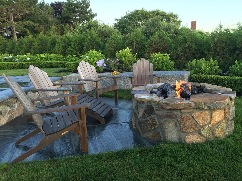 Inspiration for a mid-sized traditional backyard partial sun formal garden for spring in Portland Maine with a fire feature and natural stone pavers.