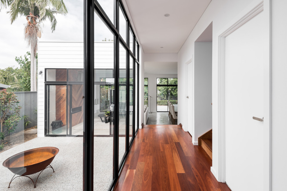 Kleiner Moderner Flur mit weißer Wandfarbe und braunem Holzboden in Perth