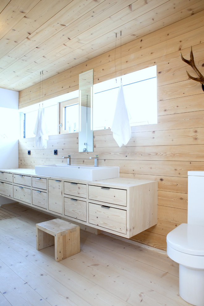 Badezimmer En Suite With flächenbündigen Schrankfronten, hellen Holzschränken, freistehender Badewanne, bodengleicher Dusche, Wandtoilette, beiger Wandfarbe, gebeiztem Holzboden, Aufsatzwaschbecken, Waschtisch aus Holz, beigem Boden, offener Dusche and brauner Waschtischplatte in Stuttgart