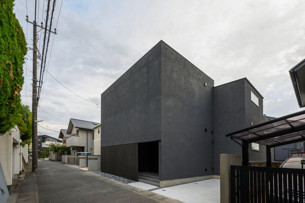 На фото: двухэтажный, серый частный загородный дом среднего размера в современном стиле с облицовкой из бетона, плоской крышей, крышей из смешанных материалов и черной крышей