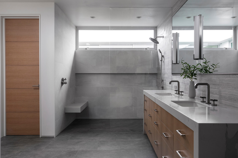Photo of a mid-sized modern master bathroom in Orange County with flat-panel cabinets, light wood cabinets, an open shower, a bidet, porcelain tile, grey walls, porcelain floors, an undermount sink, marble benchtops, grey floor, an open shower, white benchtops, a shower seat, a double vanity and a built-in vanity.