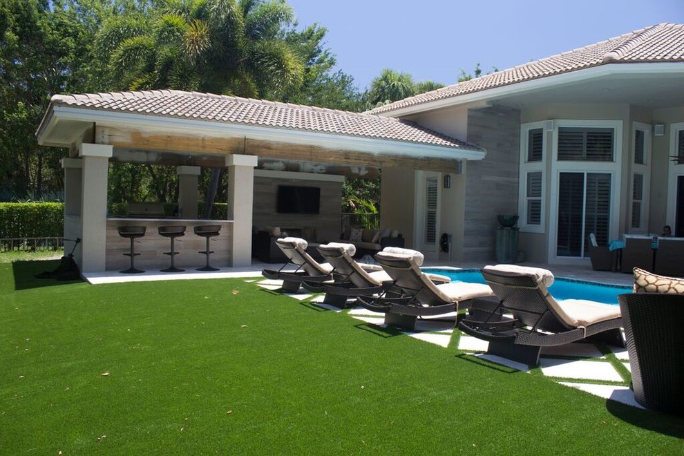 Photo of a large transitional backyard patio in Miami with an outdoor kitchen, natural stone pavers and a gazebo/cabana.