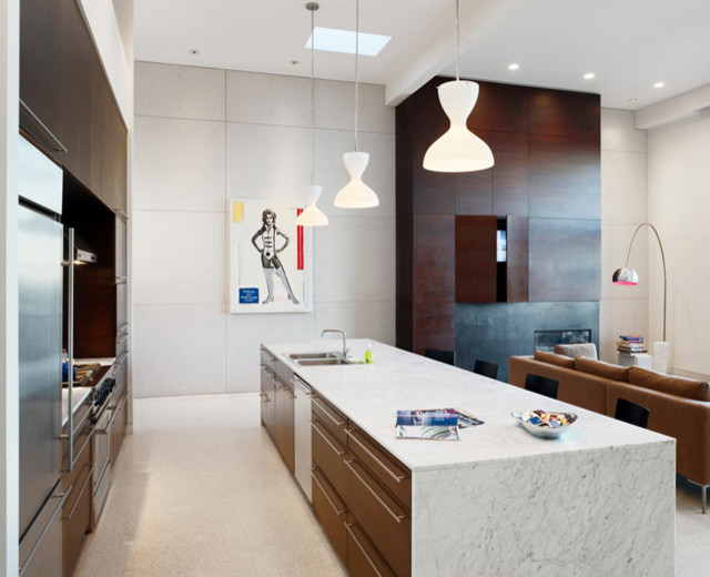 This is an example of a mid-sized modern single-wall open plan kitchen in San Francisco with a drop-in sink, flat-panel cabinets, dark wood cabinets, marble benchtops, white splashback, stone slab splashback, stainless steel appliances, linoleum floors and with island.