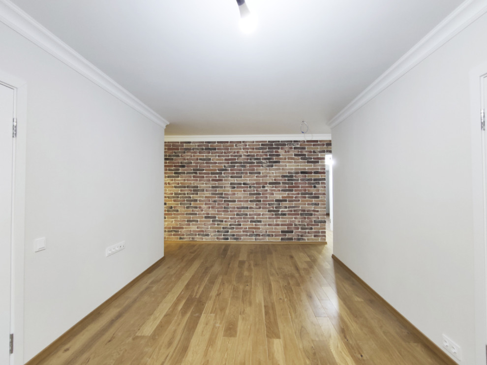 Esempio di un soggiorno di medie dimensioni con pareti bianche, pavimento in legno massello medio, pavimento marrone e pareti in mattoni