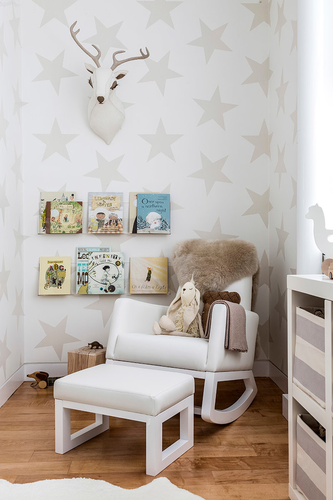 Contemporary gender-neutral nursery in New York with multi-coloured walls and light hardwood floors.