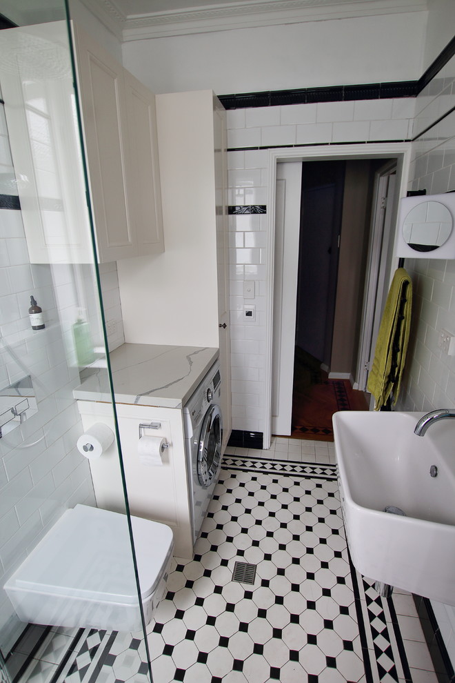 Inspiration for a mid-sized traditional master bathroom in Sydney with recessed-panel cabinets, white cabinets, a corner tub, an open shower, a wall-mount toilet, black and white tile, ceramic tile, white walls, ceramic floors, a wall-mount sink, engineered quartz benchtops, white floor, an open shower and white benchtops.