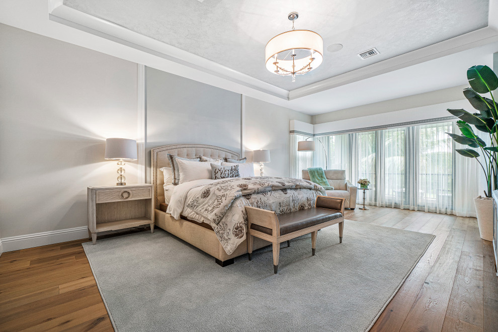 Photo of a large traditional guest bedroom in Miami with grey walls, medium hardwood flooring, brown floors and a coffered ceiling.