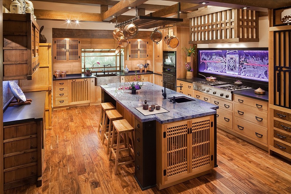 Large asian u-shaped separate kitchen in Los Angeles with medium wood cabinets, granite benchtops, with island, an undermount sink, black appliances and medium hardwood floors.