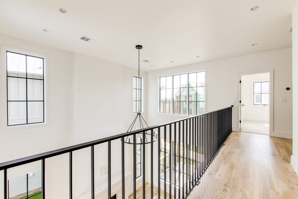Foto de escalera recta campestre de tamaño medio con contrahuellas de madera y barandilla de metal
