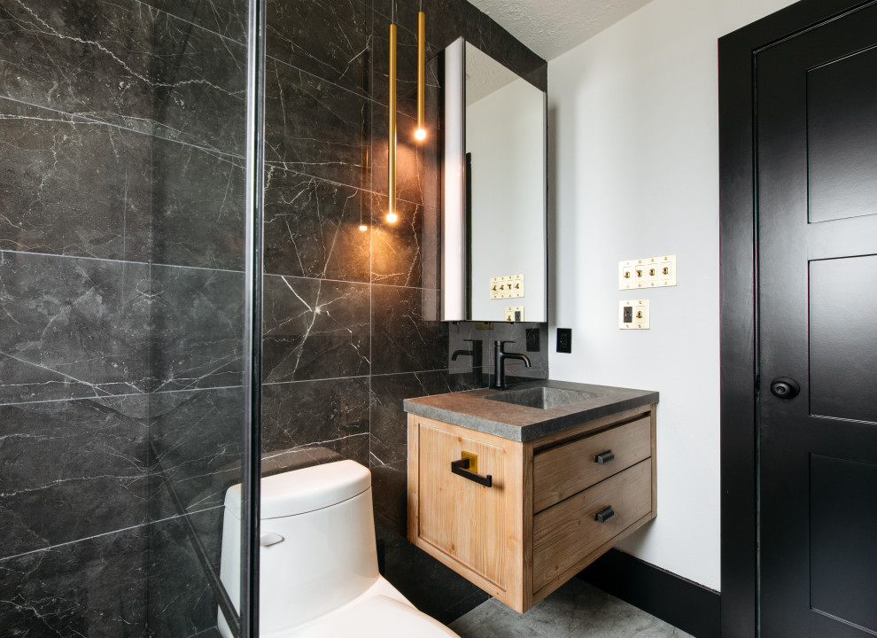 Modernes Duschbad mit flächenbündigen Schrankfronten, hellbraunen Holzschränken, Toilette mit Aufsatzspülkasten, schwarzen Fliesen, weißer Wandfarbe, integriertem Waschbecken, grauem Boden, grauer Waschtischplatte, Einzelwaschbecken und schwebendem Waschtisch in Houston