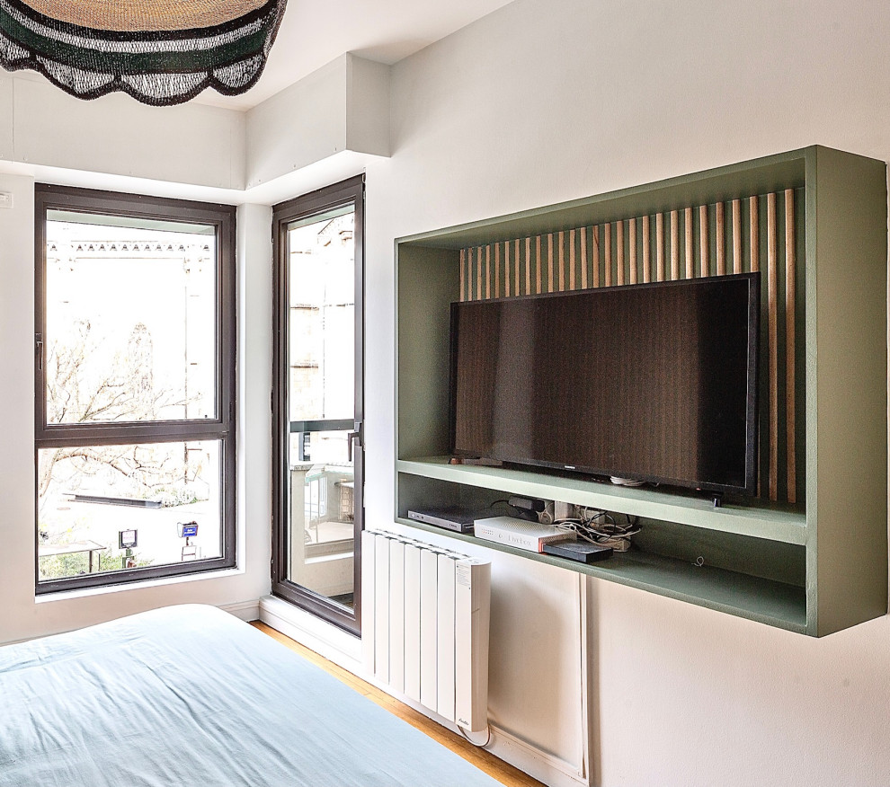 Ejemplo de dormitorio principal romántico de tamaño medio con paredes verdes, suelo de madera clara, suelo marrón, madera y papel pintado