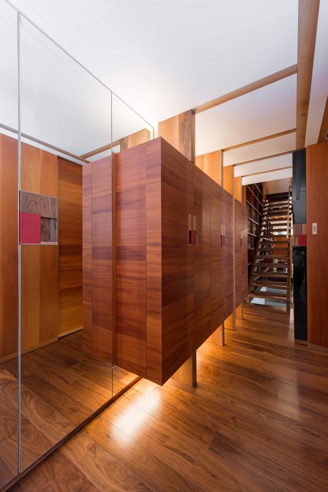 Esempio di una lavanderia multiuso contemporanea di medie dimensioni con ante in legno bruno, pareti bianche, parquet scuro e pavimento marrone