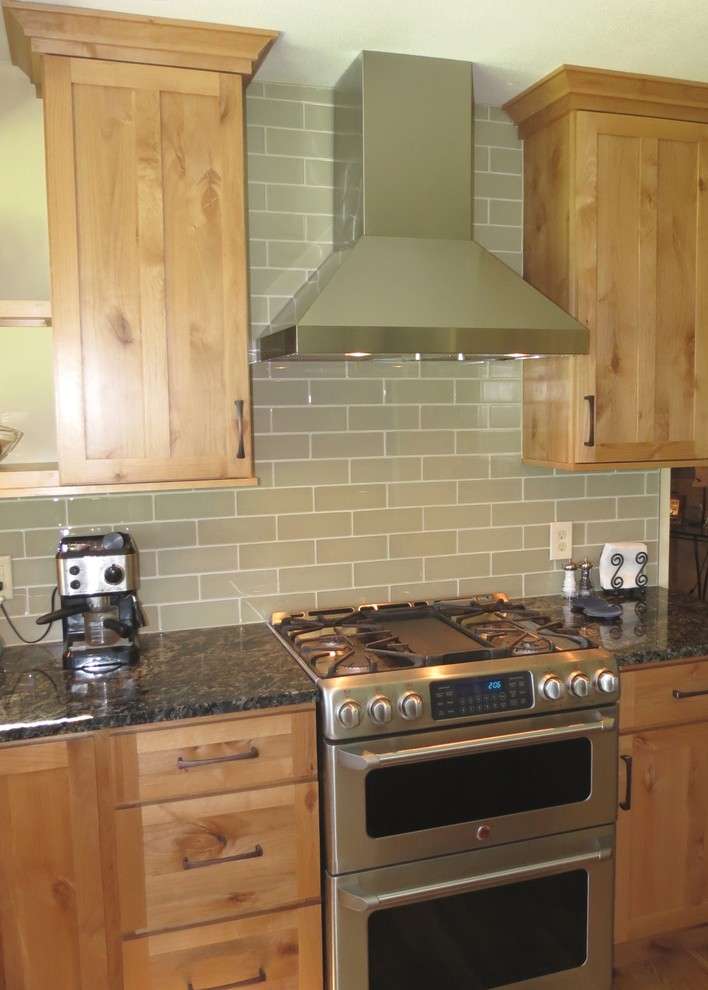 Example of a mid-sized transitional u-shaped light wood floor open concept kitchen design in Denver with an undermount sink, shaker cabinets, light wood cabinets, granite countertops, beige backsplash, glass tile backsplash, stainless steel appliances and an island