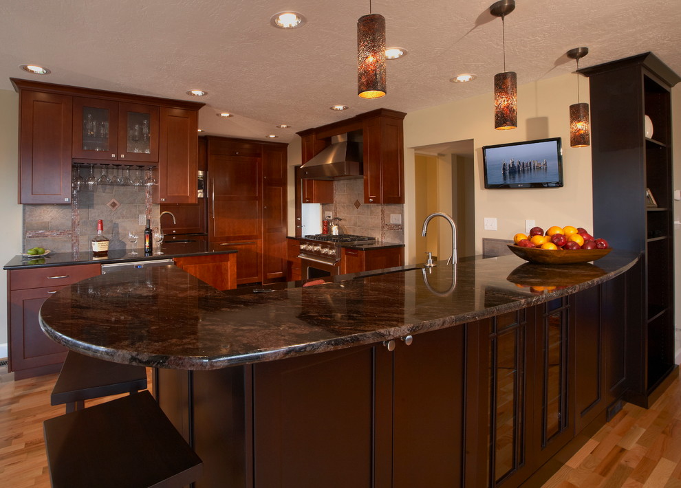 Mid-sized transitional l-shaped light wood floor and beige floor open concept kitchen photo in Seattle with an undermount sink, raised-panel cabinets, medium tone wood cabinets, granite countertops, metallic backsplash, ceramic backsplash, stainless steel appliances and no island