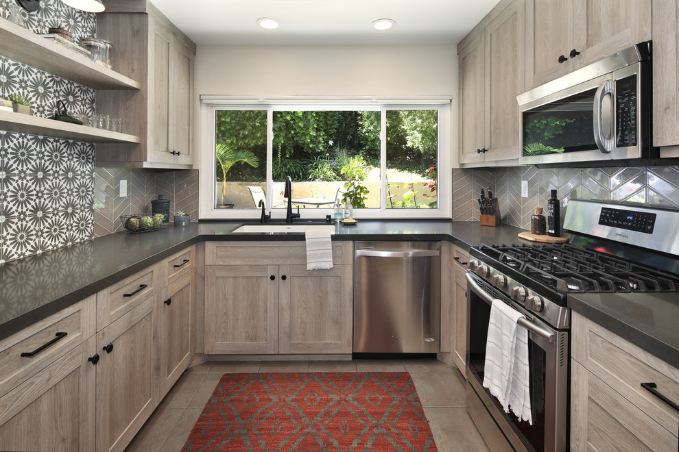 Design ideas for a mid-sized transitional u-shaped kitchen in Orange County with an undermount sink, shaker cabinets, distressed cabinets, quartz benchtops, stainless steel appliances, with island, grey benchtop, grey splashback and beige floor.