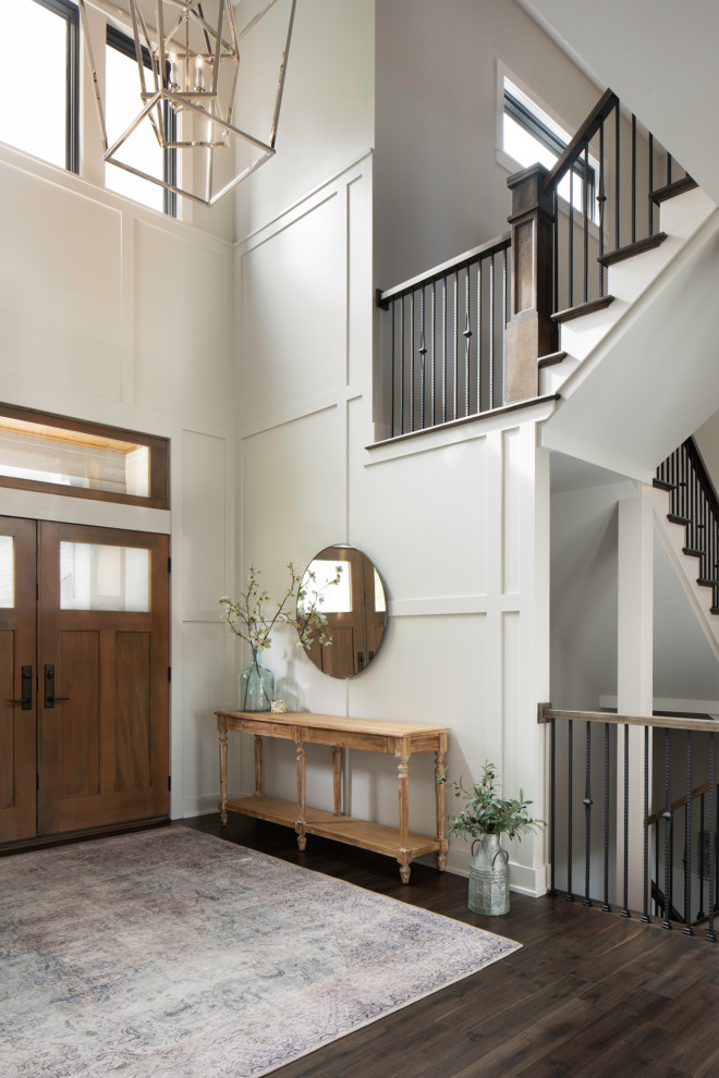 Inspiration for an expansive transitional foyer in Milwaukee with grey walls, dark hardwood floors, a double front door, a dark wood front door, brown floor, recessed and wood walls.