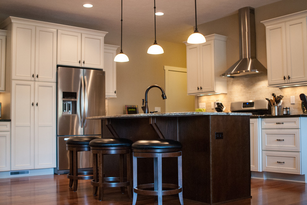 Inspiration for a traditional kitchen in Grand Rapids with an undermount sink, solid surface benchtops, ceramic splashback, stainless steel appliances and medium hardwood floors.