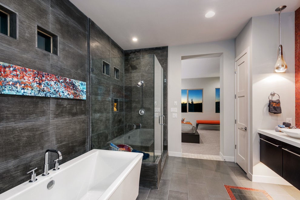 Photo of a contemporary master bathroom in Philadelphia with flat-panel cabinets, dark wood cabinets, a freestanding tub, a corner shower, a vessel sink and gray tile.