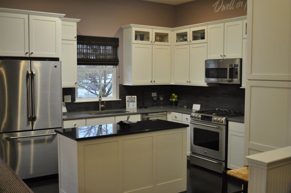 Enclosed kitchen - mid-sized transitional l-shaped black floor enclosed kitchen idea in Chicago with an undermount sink, shaker cabinets, white cabinets, stainless steel appliances and an island