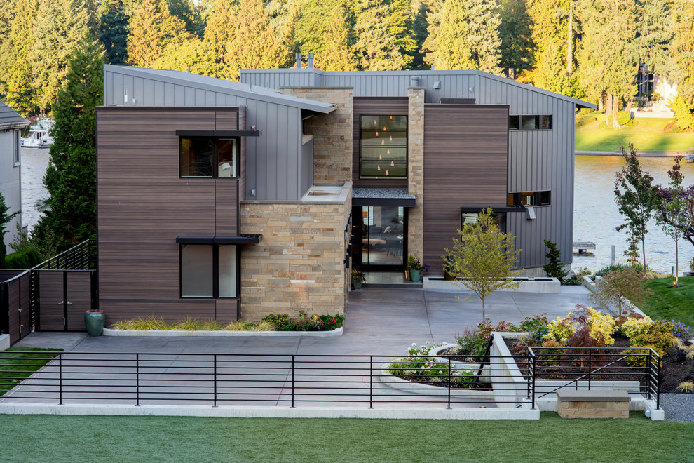 Imagen de fachada de casa marrón minimalista grande de tres plantas con revestimientos combinados, tejado de un solo tendido y tejado de metal