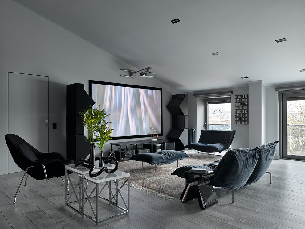 Photo of a contemporary home theatre in Moscow with white walls, light hardwood floors, a projector screen and grey floor.