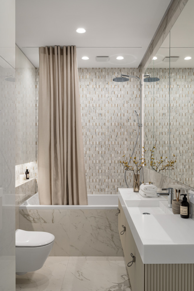 This is an example of a mid-sized contemporary master bathroom in Moscow with flat-panel cabinets, beige cabinets, an alcove tub, a shower/bathtub combo, a wall-mount toilet, beige tile, ceramic tile, beige walls, porcelain floors, a wall-mount sink, beige floor, a shower curtain, white benchtops, a laundry, a single vanity, a floating vanity and solid surface benchtops.