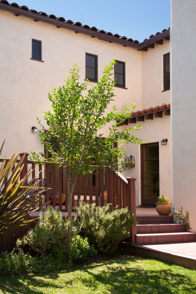 This is an example of a large mediterranean two-storey adobe beige exterior in Los Angeles with a flat roof.