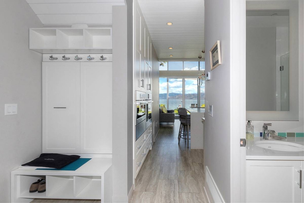 Small beach style entry hall in Vancouver with a single front door, white walls, vinyl floors, a glass front door, grey floor and timber.