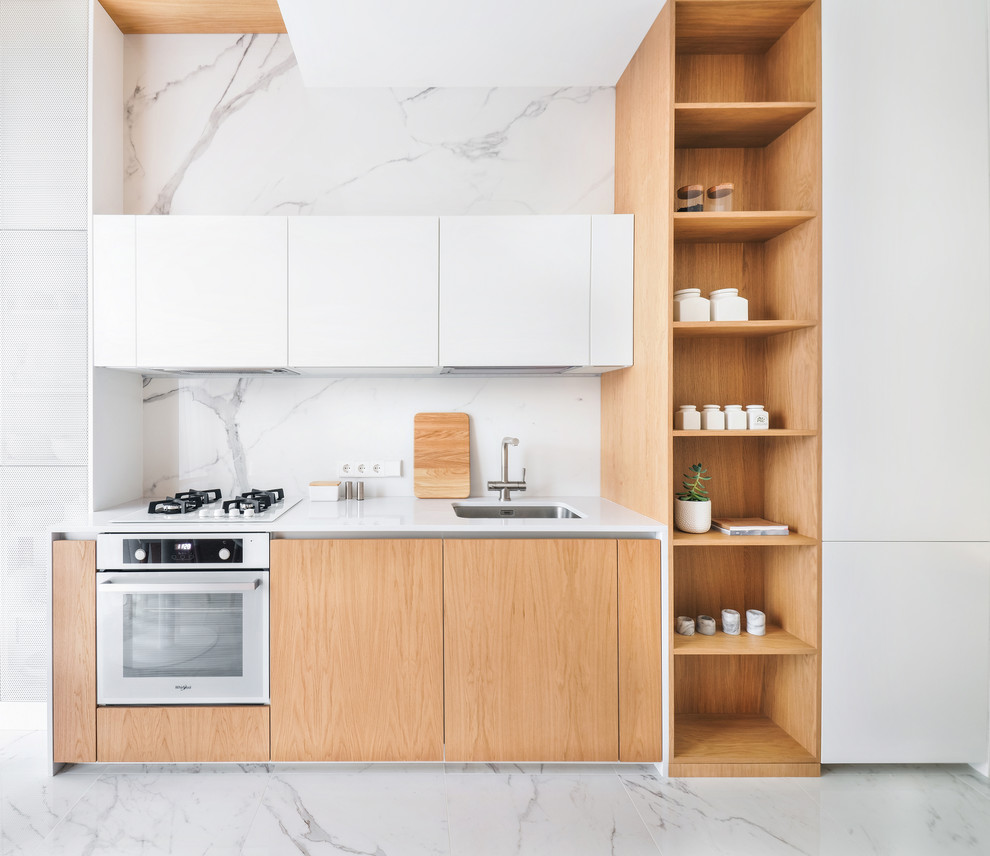 Photo of a contemporary single-wall kitchen in Other with an undermount sink, flat-panel cabinets, medium wood cabinets, white splashback, stone slab splashback, white appliances, white floor and white benchtop.