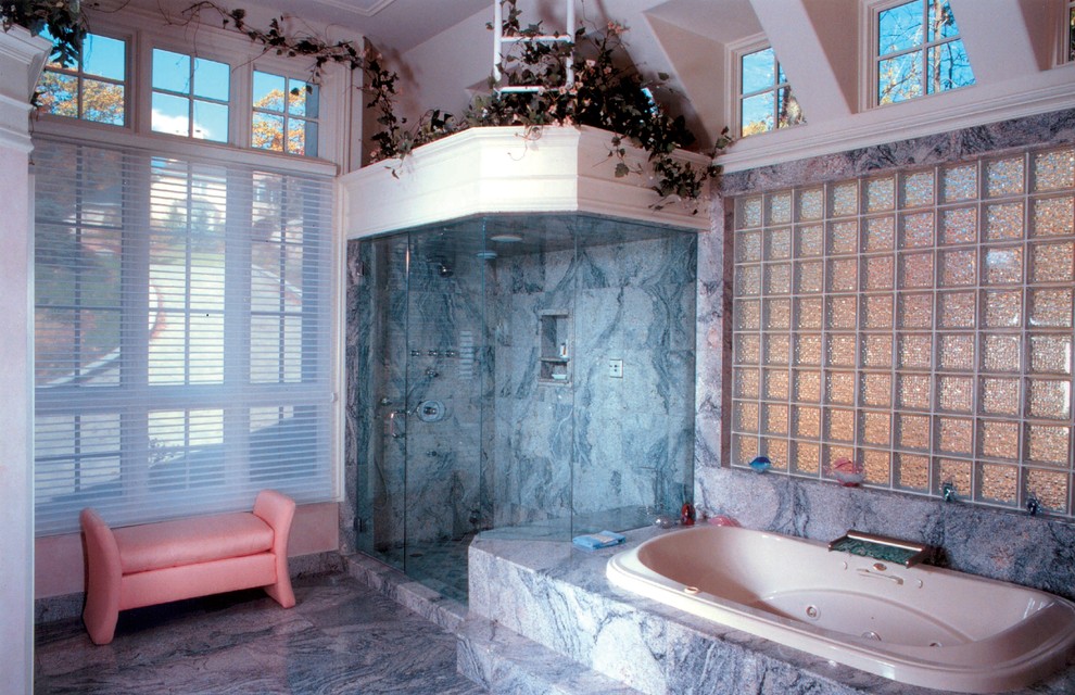 Photo of a large traditional master bathroom in New York with a drop-in tub, a corner shower, white walls and marble floors.
