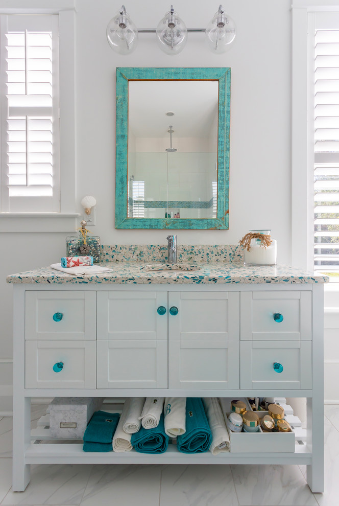 Inspiration for a small beach style master bathroom in Charleston with furniture-like cabinets, white cabinets, a freestanding tub, white walls, cement tiles, an undermount sink, terrazzo benchtops, beige floor and multi-coloured benchtops.