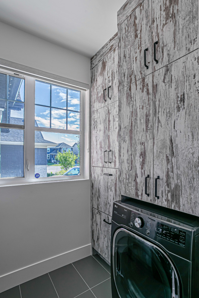 Inspiration for a small industrial u-shaped dedicated laundry room in Calgary with flat-panel cabinets, distressed cabinets, laminate benchtops, white splashback, shiplap splashback, ceramic floors, grey floor and grey benchtop.