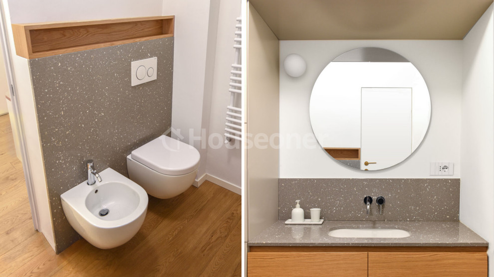 Mid-sized scandinavian powder room in Other with furniture-like cabinets, grey cabinets, a two-piece toilet, white tile, stone slab, white walls, laminate floors, a drop-in sink, engineered quartz benchtops, brown floor, grey benchtops, a built-in vanity, wood and planked wall panelling.